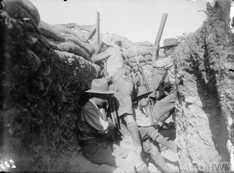 Men of the Royal Naval Division and Australians in the same trench. One is using a "sniperscope" and another a periscope. © IWM (Q 13427)