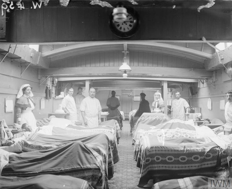 The interior of a hospital barge showing how the cargo hold has been converted into a functioning ward. © IWM (Q 33443)
