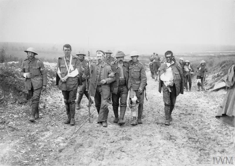 Battle of Bazentin Ridge. Five British and German walking wounded, injured in their arms and legs, on the way to a dressing station near Bernafay Wood, July 1916. B© IWM (Q 800)