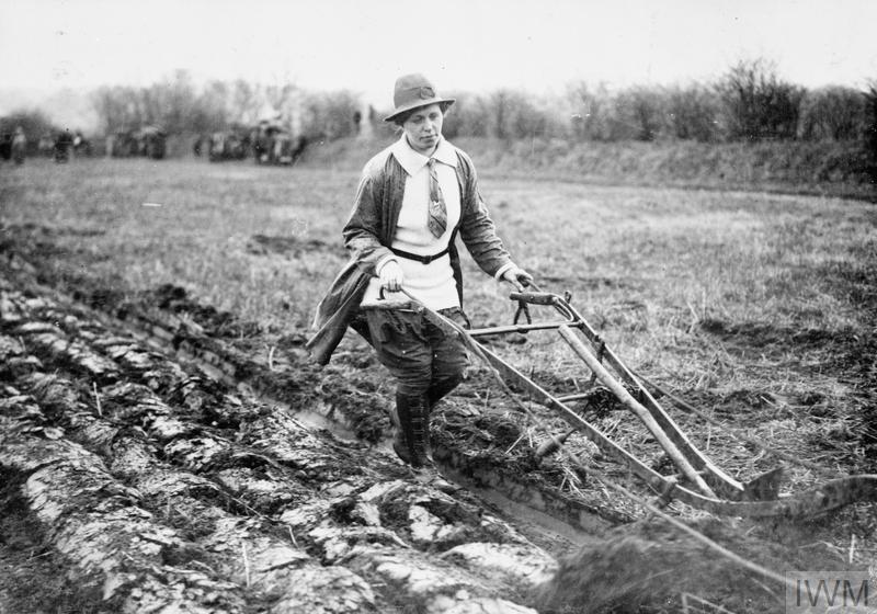 A member of the Women's Land Army operating a single-furrow plough on a British farm. © IWM (Q 54607)