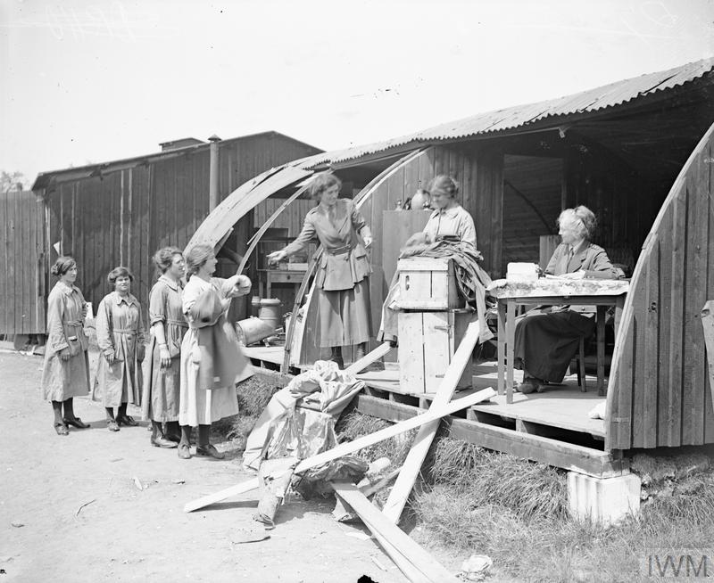 Clothing is being issued by the Women's Army Auxiliary Corps (WAAC) from a Nissen hut damaged by an air raid at Abbeville, 22 May 1918. © IWM (Q 7885)